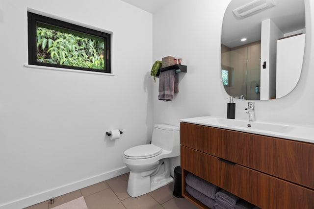 bathroom with a wealth of natural light, tile patterned flooring, a shower with shower door, vanity, and toilet