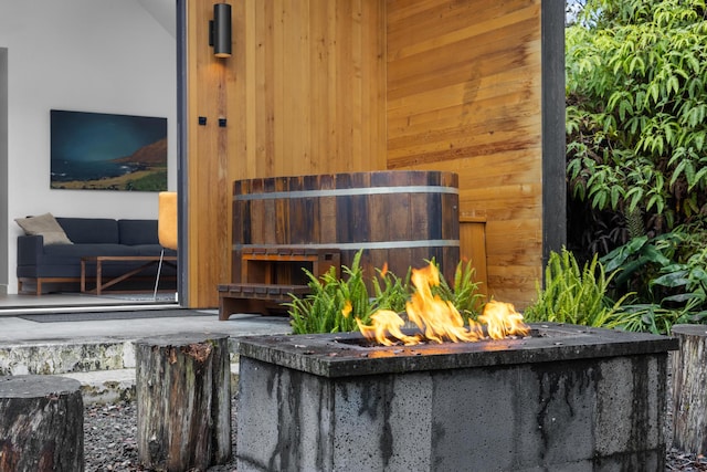 details featuring wooden walls and a fire pit