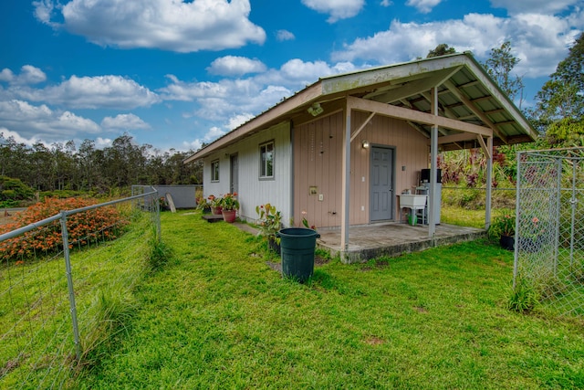 back of property featuring an outbuilding and a yard