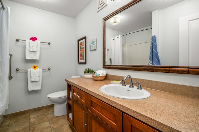 bathroom featuring tile patterned floors, vanity, toilet, and walk in shower