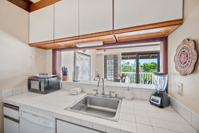 kitchen with white cabinetry, white dishwasher, beam ceiling, tile counters, and sink