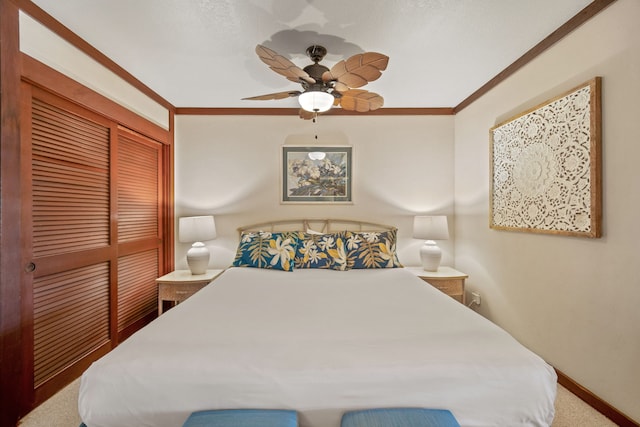 carpeted bedroom with a closet, ceiling fan, and crown molding