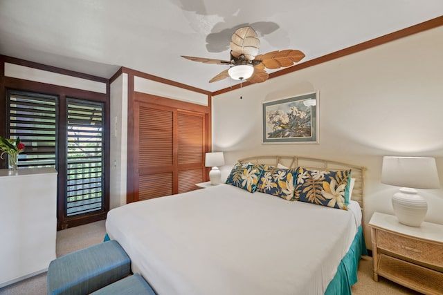 bedroom featuring ornamental molding, a closet, ceiling fan, and light colored carpet