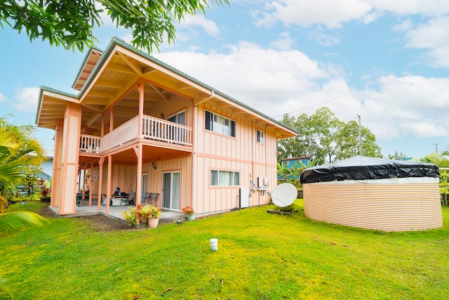 back of property featuring a yard, a balcony, and a patio area