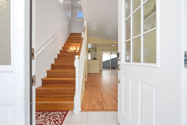 stairway featuring vaulted ceiling and tile patterned floors