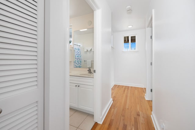 corridor featuring sink and light hardwood / wood-style flooring