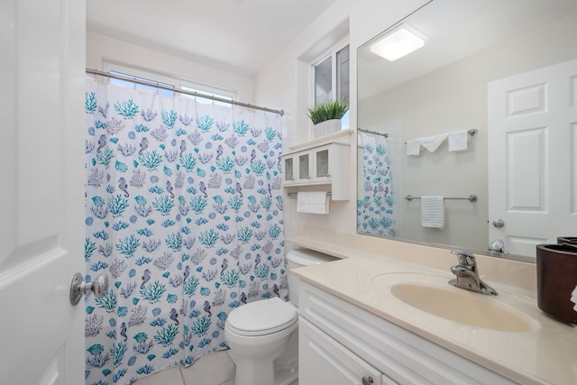 bathroom with tile patterned flooring, a shower with curtain, vanity, and toilet