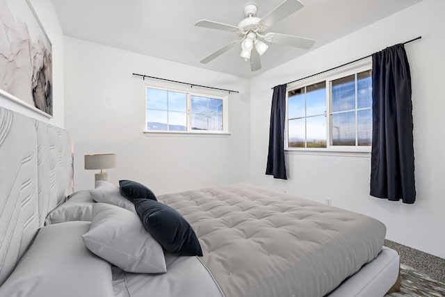 bedroom featuring multiple windows, ceiling fan, and carpet