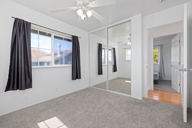 unfurnished bedroom featuring carpet, multiple windows, and ceiling fan