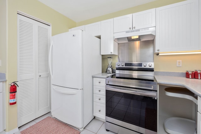 kitchen featuring white refrigerator, electric range, white cabinets, and light tile patterned floors