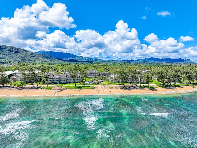 drone / aerial view featuring a water and mountain view and a beach view