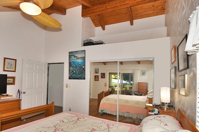 bedroom with wood ceiling, beamed ceiling, ceiling fan, and a closet