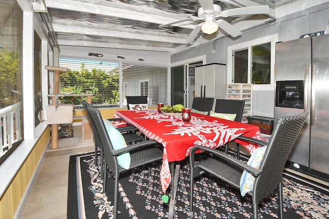 sunroom / solarium featuring ceiling fan and beamed ceiling