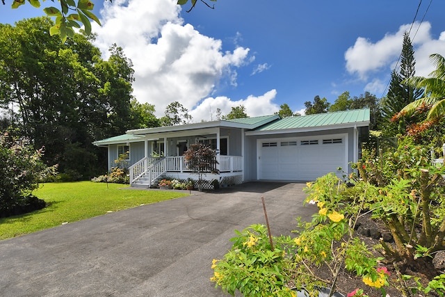 single story home featuring a porch, a garage, and a front yard