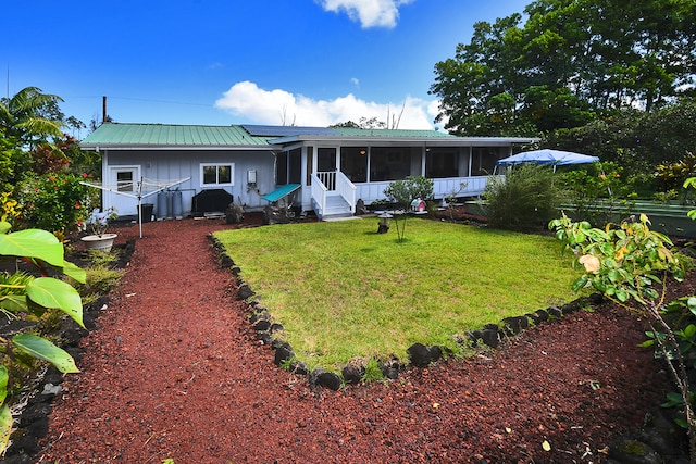 back of house featuring a sunroom and a lawn