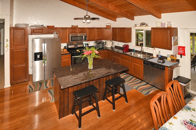 kitchen featuring lofted ceiling with beams, a wealth of natural light, appliances with stainless steel finishes, and sink