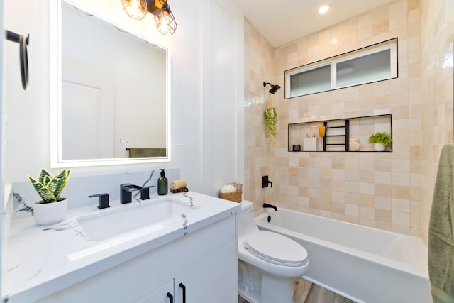 full bathroom featuring tiled shower / bath, toilet, vanity, and hardwood / wood-style flooring