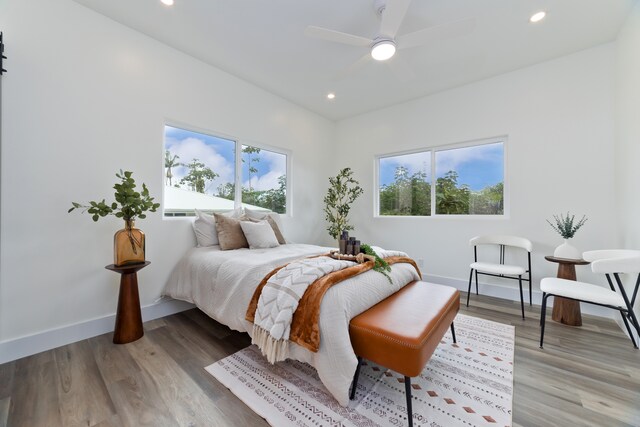 bedroom featuring multiple windows, ceiling fan, and light wood-type flooring