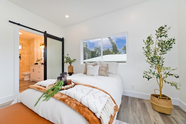 16-2157 Jewel Dr, Pahoa, HI 96778 - bedroom with a barn door, wood finished floors, ensuite bath, baseboards, and recessed lighting