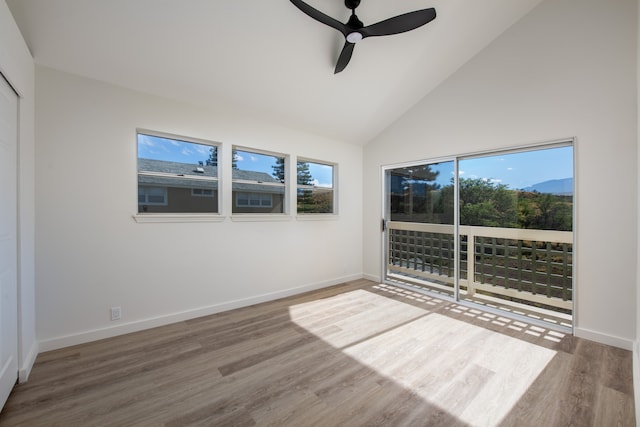 spare room featuring ceiling fan, plenty of natural light, hardwood / wood-style floors, and high vaulted ceiling