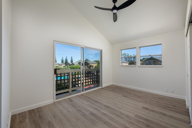 empty room with hardwood / wood-style floors, ceiling fan, and high vaulted ceiling