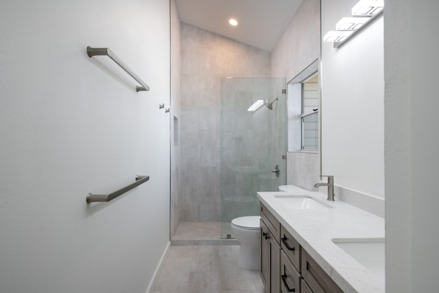 bathroom with vaulted ceiling, tiled shower, vanity, tile patterned flooring, and toilet