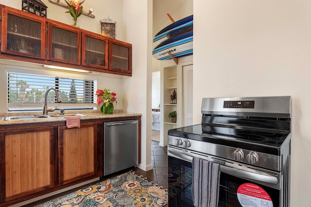 kitchen featuring light stone counters, stainless steel appliances, and sink