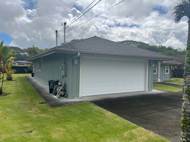 view of side of home featuring a garage and a yard