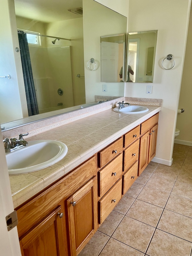 full bathroom featuring shower / bath combo with shower curtain, tile patterned flooring, vanity, and toilet