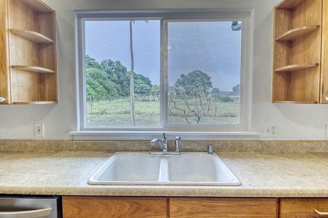 kitchen with brown cabinetry, a sink, open shelves, and a wealth of natural light