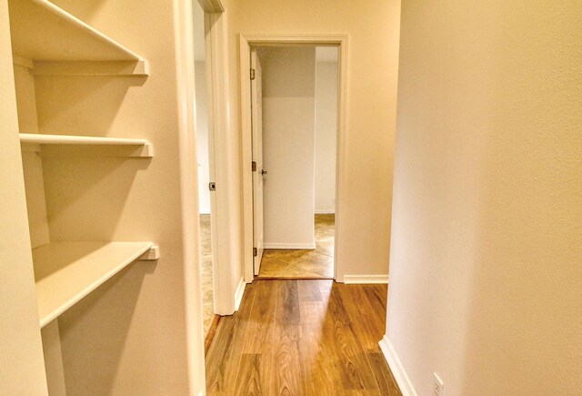 hall featuring baseboards and wood finished floors