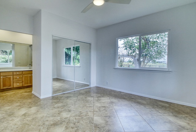 unfurnished bedroom with ceiling fan and a closet