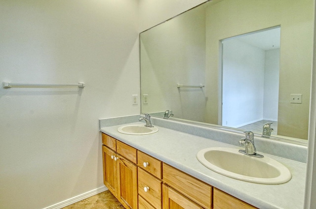 full bathroom with baseboards, double vanity, and a sink