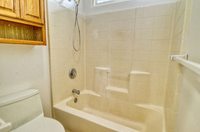 bathroom featuring tiled shower / bath combo and toilet