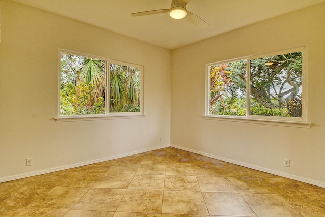 tiled spare room with a ceiling fan and baseboards