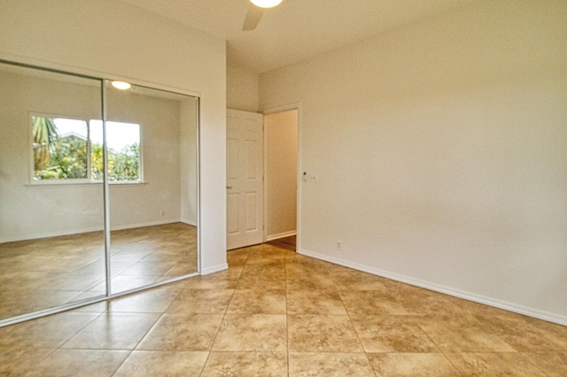 unfurnished bedroom featuring ceiling fan, baseboards, and a closet
