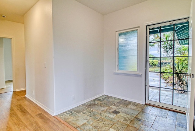 spare room featuring baseboards and stone finish flooring