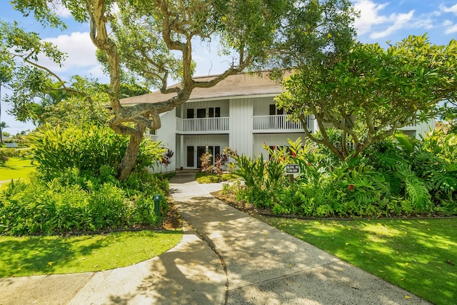 view of front of home featuring a front yard and a balcony