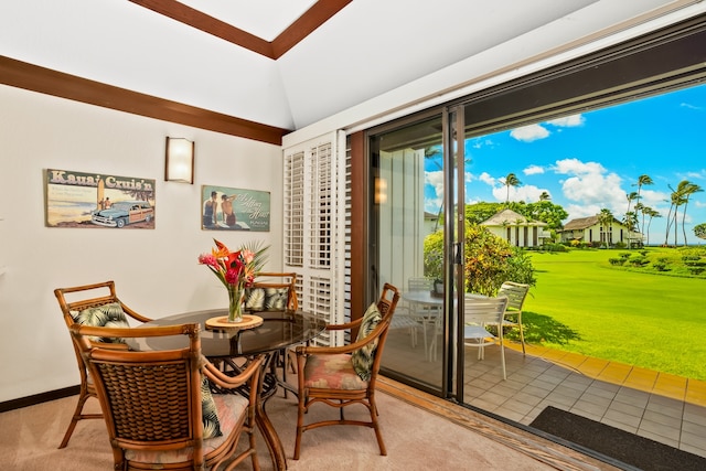 carpeted dining room featuring vaulted ceiling