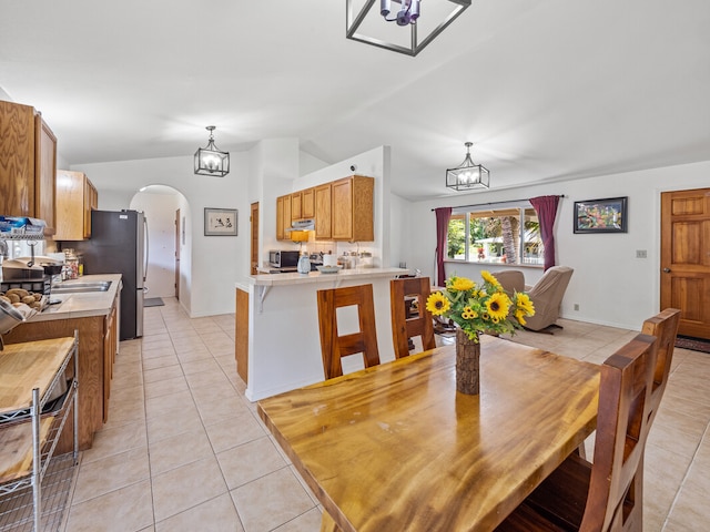 tiled dining room featuring vaulted ceiling