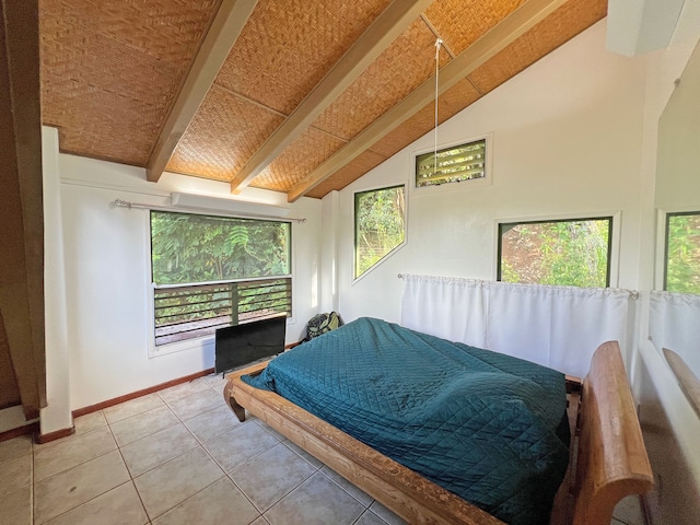 tiled bedroom featuring multiple windows and lofted ceiling with beams