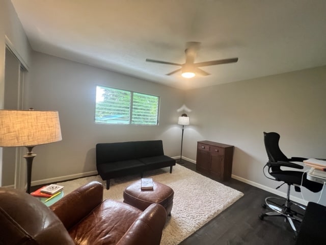 home office featuring dark wood-type flooring and ceiling fan