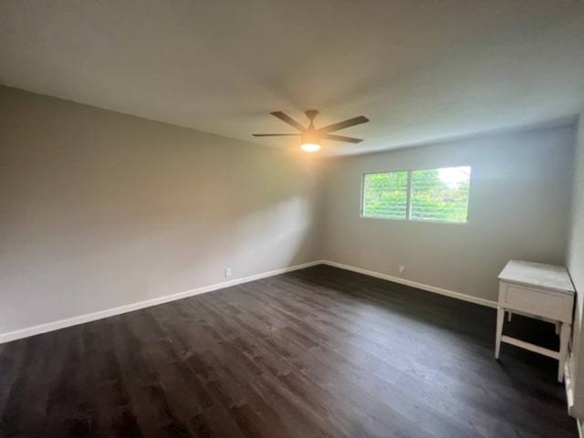 unfurnished room with dark hardwood / wood-style floors and ceiling fan