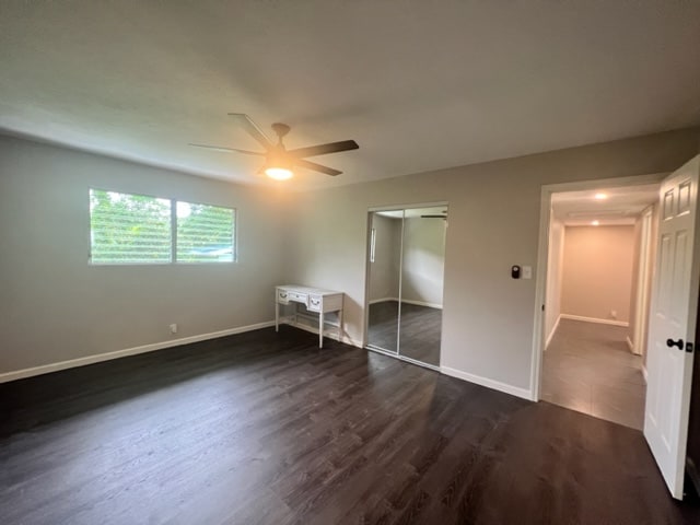 unfurnished bedroom featuring ceiling fan and dark hardwood / wood-style floors