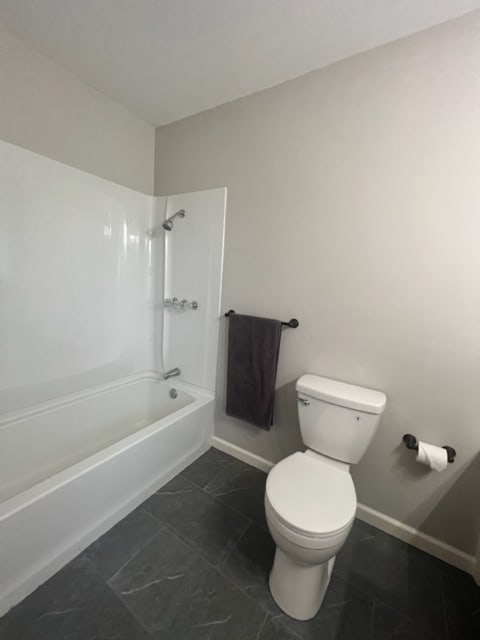 bathroom featuring toilet and a washtub