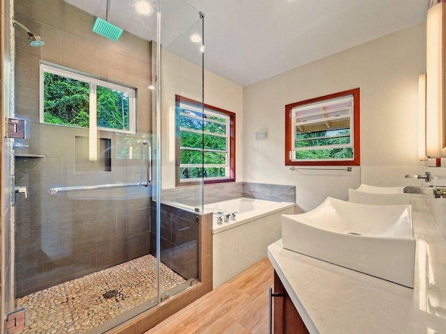 bathroom featuring shower with separate bathtub, hardwood / wood-style floors, and vanity