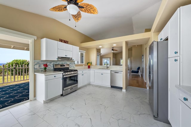 kitchen with decorative backsplash, sink, vaulted ceiling, white cabinetry, and appliances with stainless steel finishes