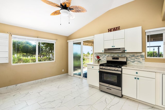 kitchen with tasteful backsplash, ceiling fan, vaulted ceiling, white cabinets, and stainless steel gas range