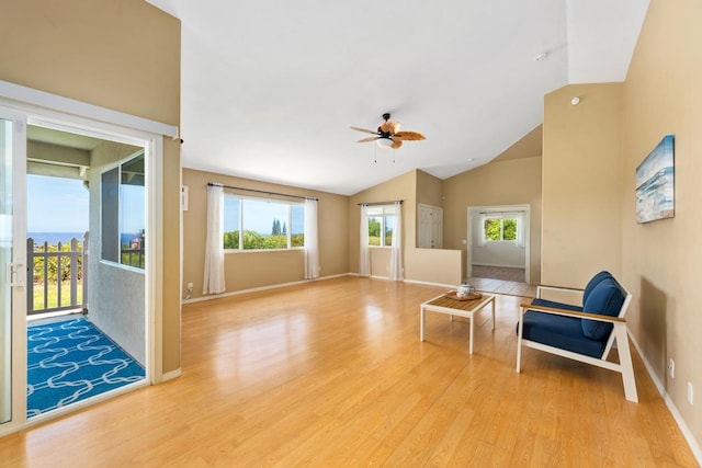 living area featuring light hardwood / wood-style floors, a healthy amount of sunlight, high vaulted ceiling, and ceiling fan