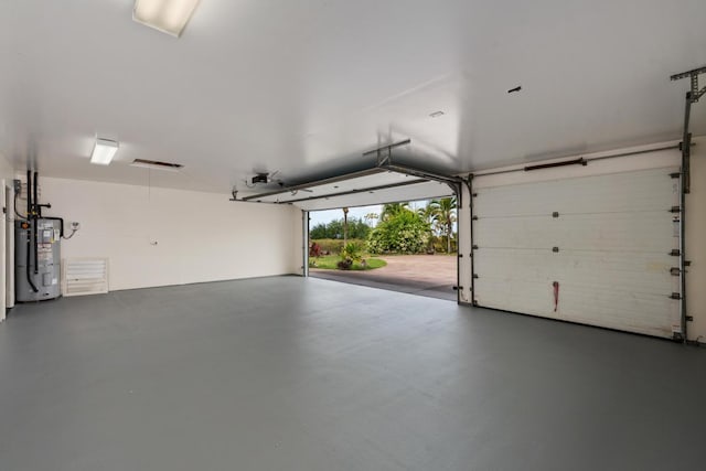 garage with a garage door opener and electric water heater